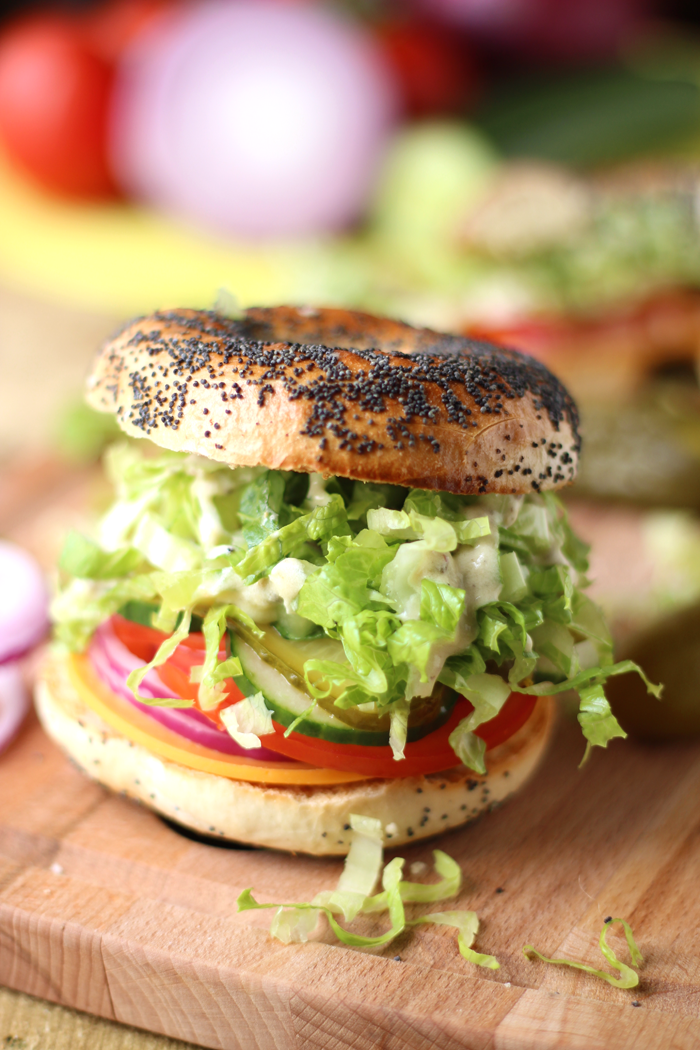 A crunchy vegan Caesar salad packed into a bagel drenched in dressing.