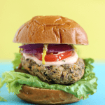 Sweet potato and black bean burger on a blue table in front of a yellow wall