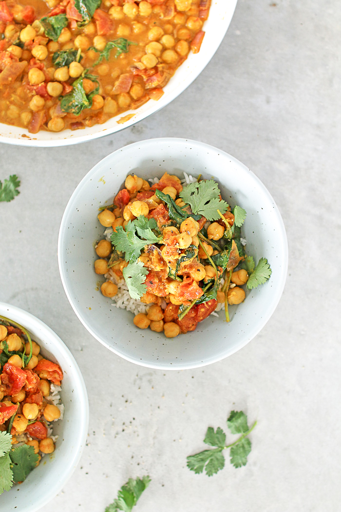 chickpea curry in a white bowl on a grey surface