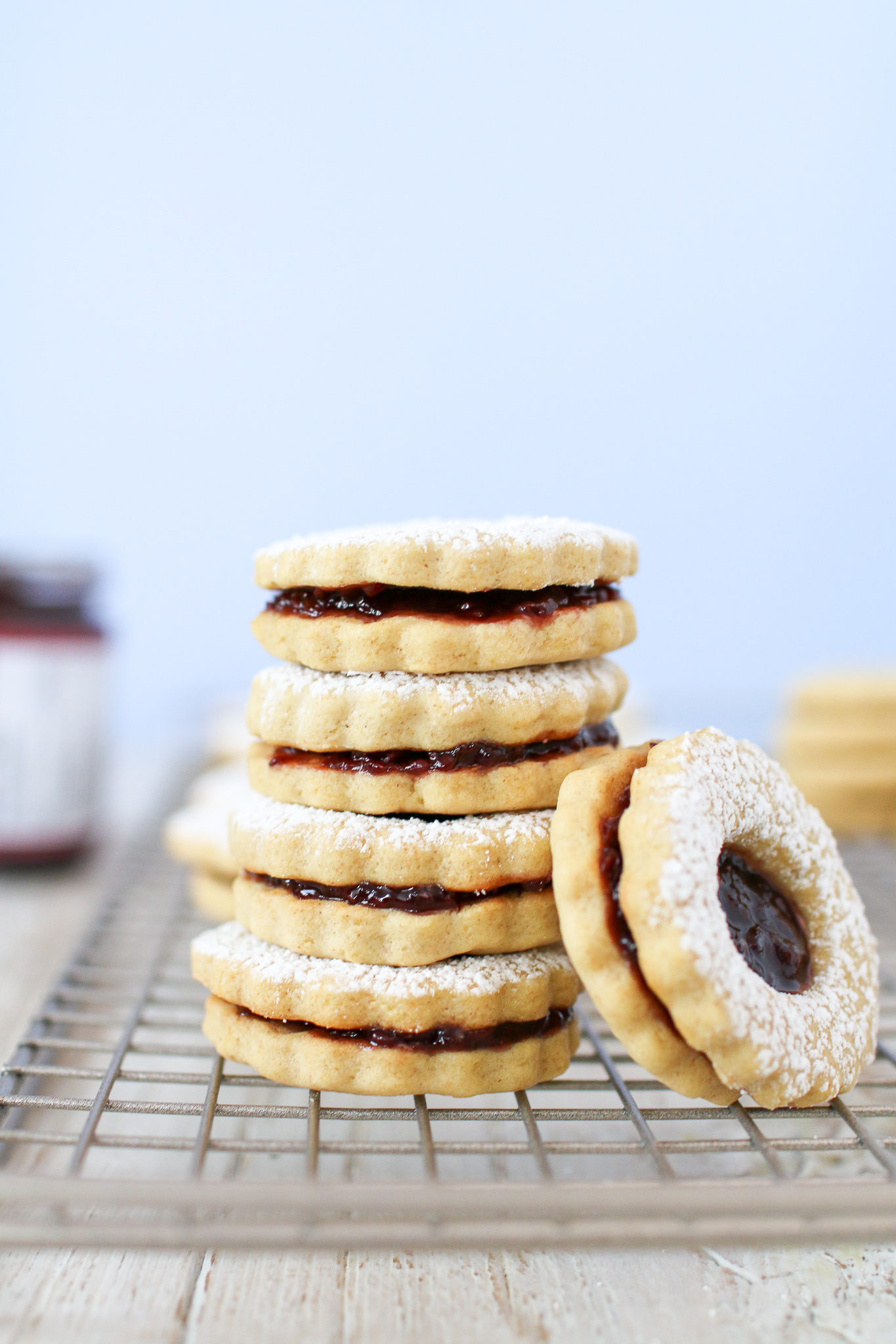 Healthier holiday linzer cookies filled with perfectly tart raspberry jam and covered in a dusting of powdered sugar for a beautiful and delicious treat!