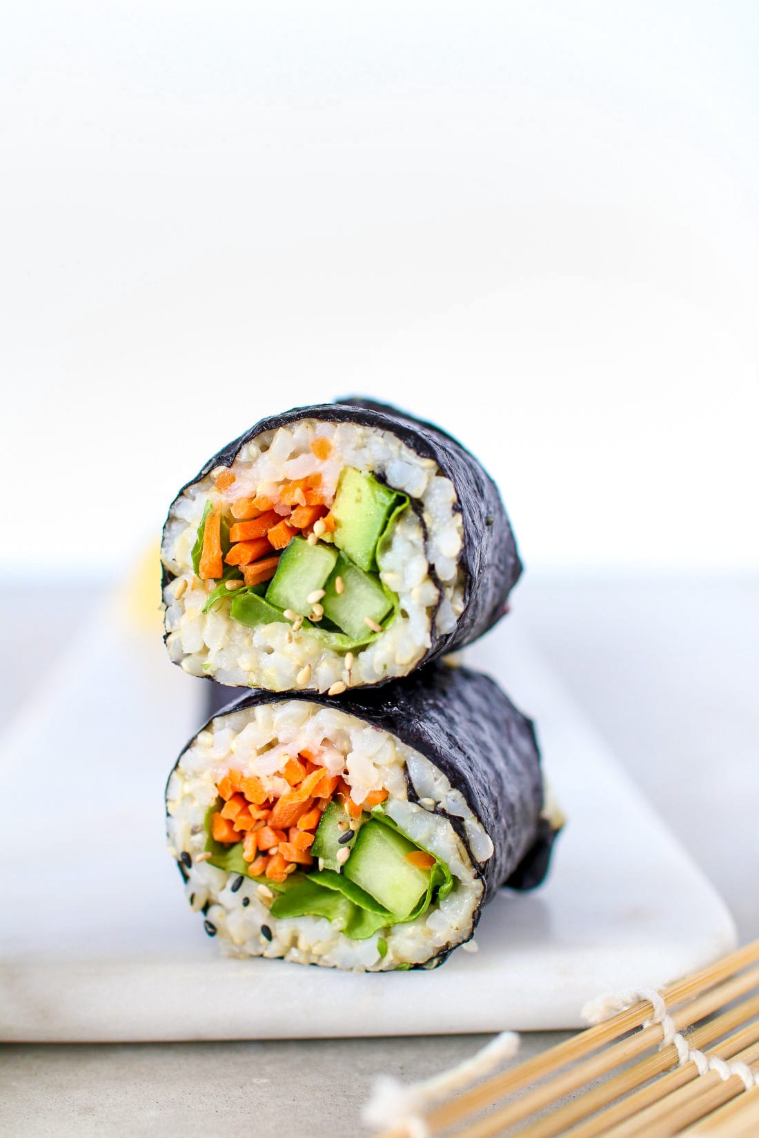 Diese gesunden Sushi-Rollen aus braunem Reis sind mit buntem Gemüse gefüllt und mit geröstetem Seetang umhüllt.