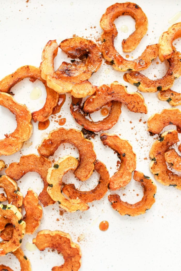 Buttery roasted delicata squash glazed with maple syrup and warming cinnamon for spice to create the perfect festive fall side to your dinner table. 