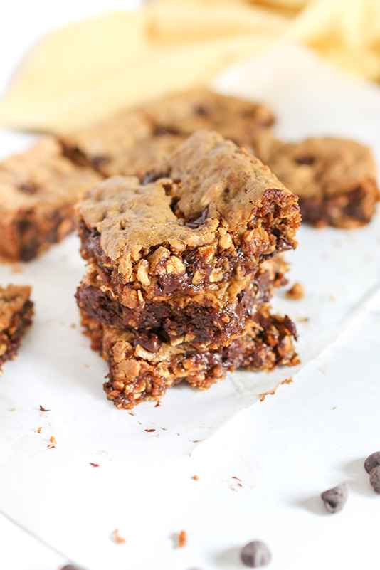 peanut butter cookie bars piled on top of each other on a white table