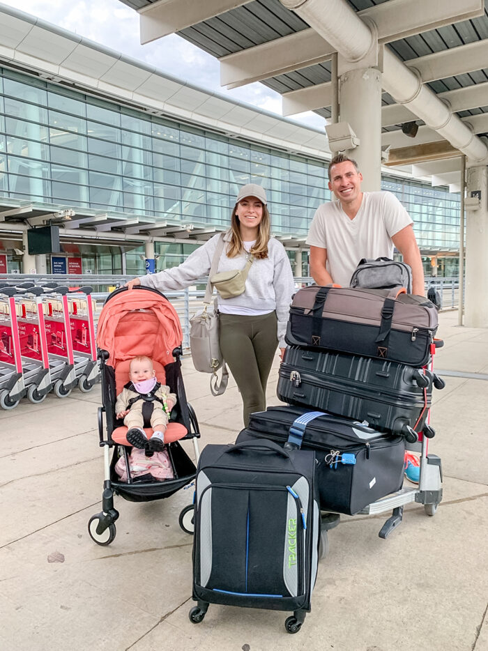 a family at the airport pushing luggage and a pushchair