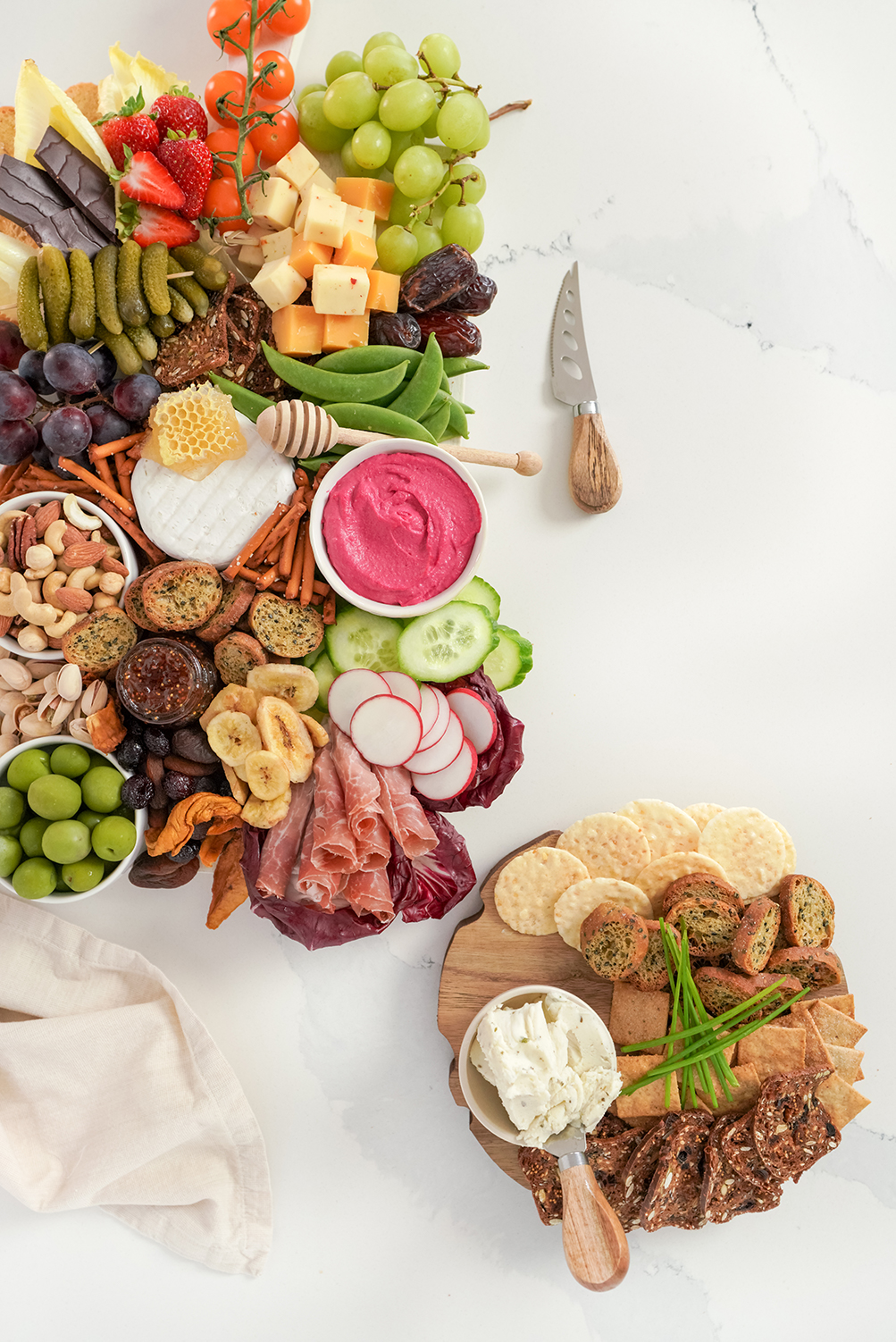 cheese, veggies, fruits and crackers on a wooden board