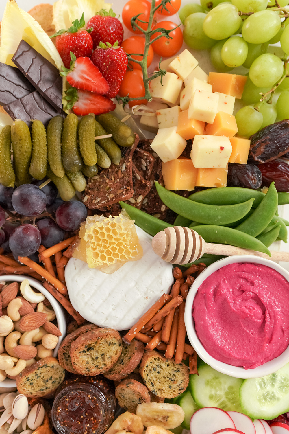 close up on the cheese, pickles and dips on a charcuterie board