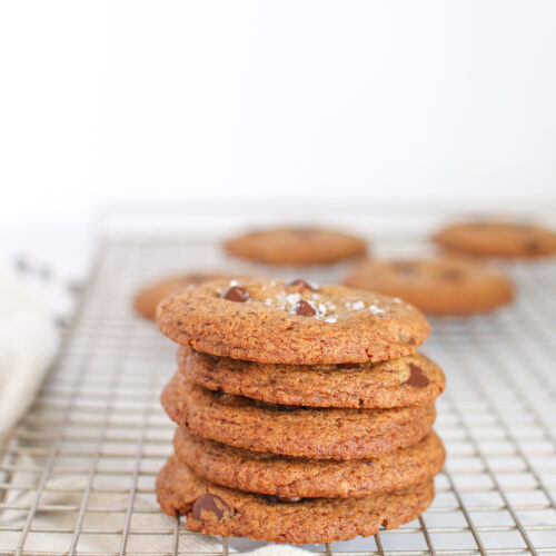 a stack of chewy chocolate chip cookies on a wire cooling rack