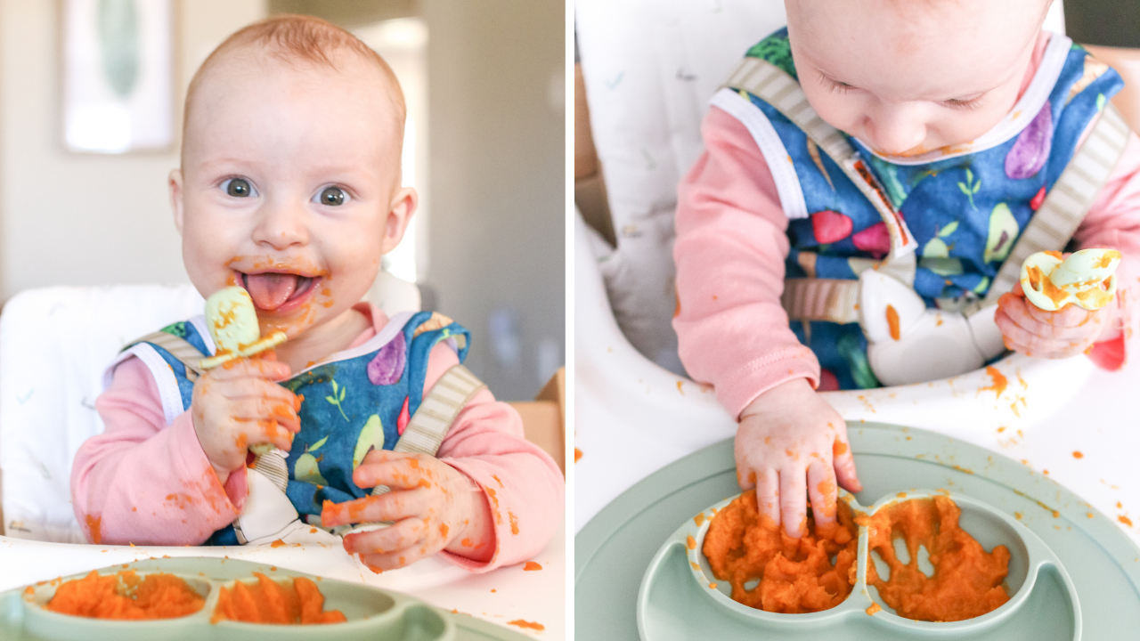 A 7 month old baby eating a carrot puree while wearing a blue bib