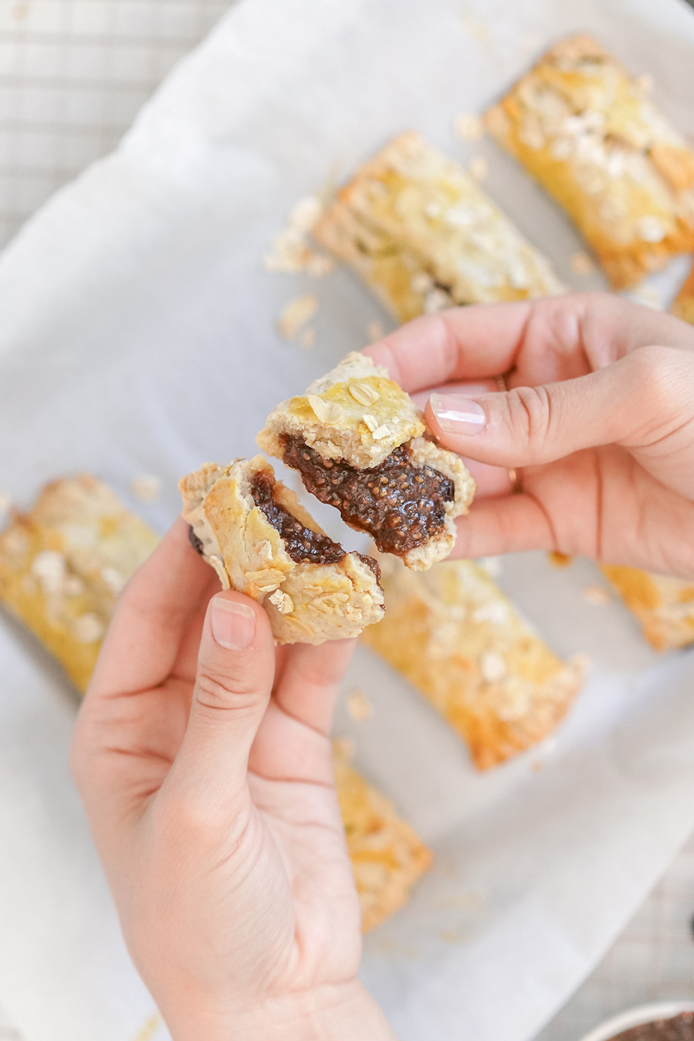 hands breaking apart a chia prune healthy energy bar