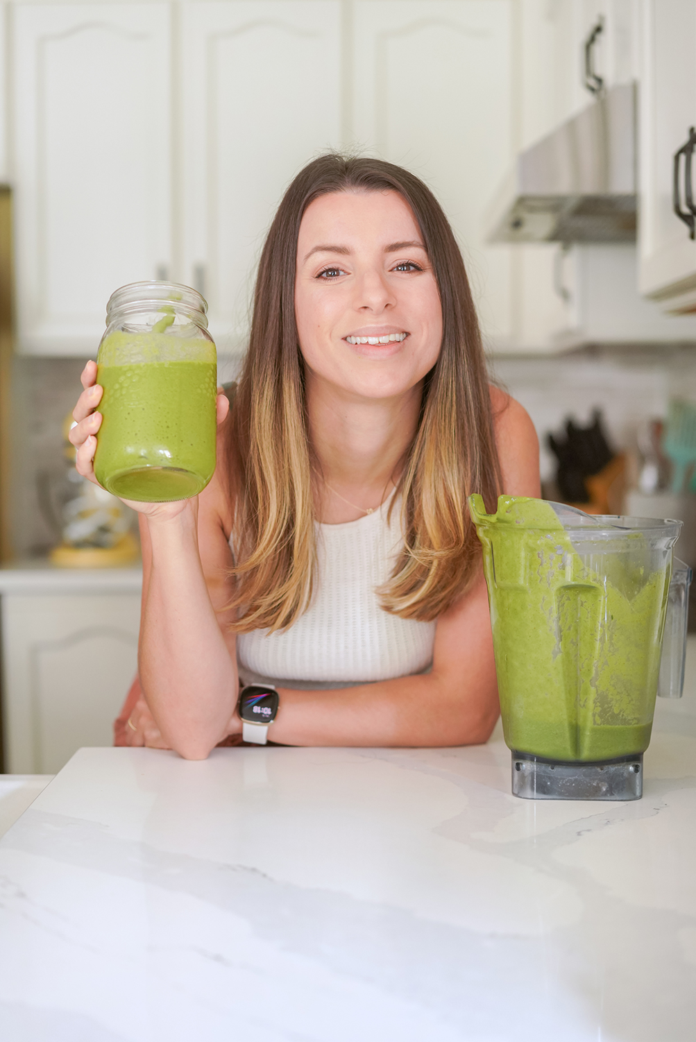 a woman drinking a green smoothie