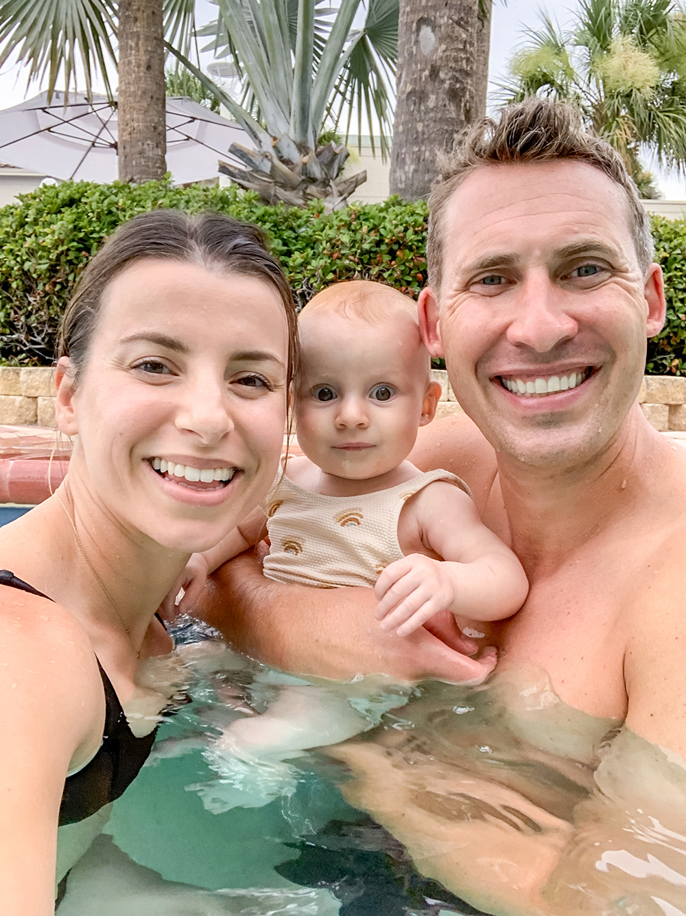mother and father in a swimming pool with their baby