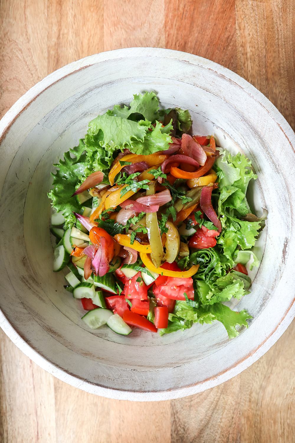 a bowl of salad on a wood table