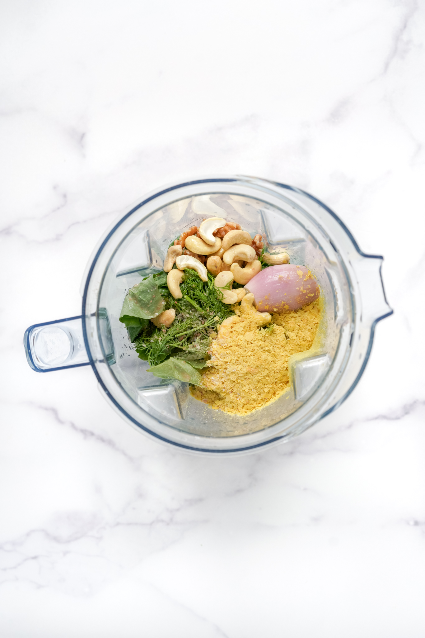 ingredients for the TikTok green goddess dressing in a blender on a marble countertop