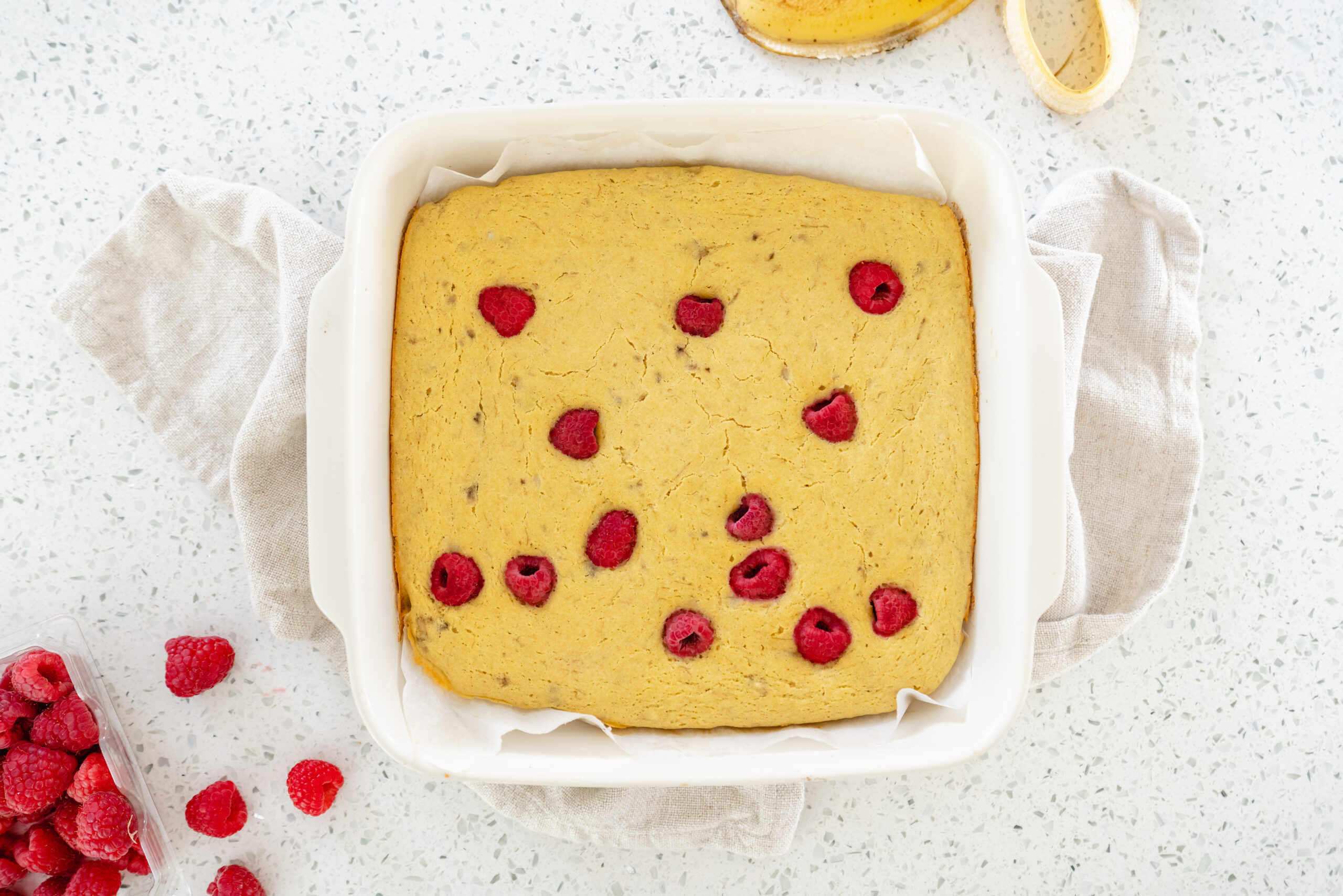 close up of baked pancake in pan with raspberries 