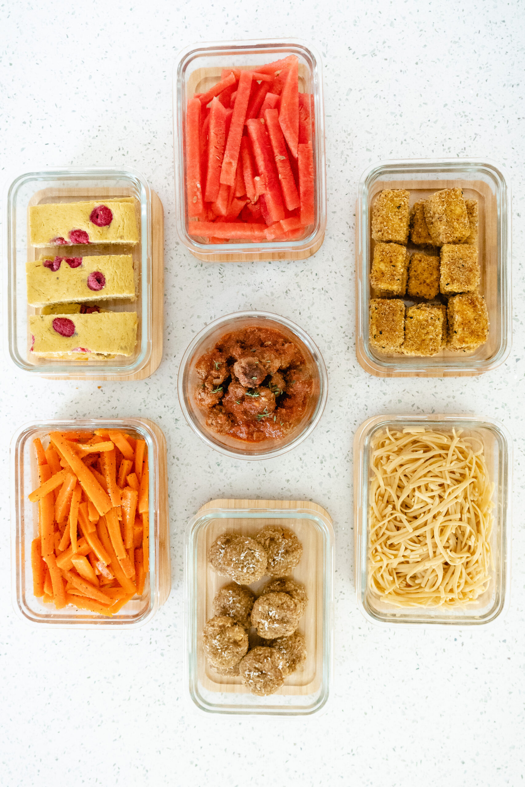 meal prepped baked pancakes, watermelon sticks, tofu nuggets, pasta, mini meatballs, soft cookies and carrot sticks